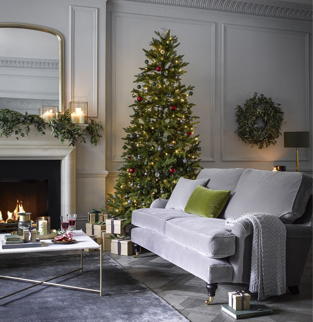 Grey Sofa next to christmas tree and presents